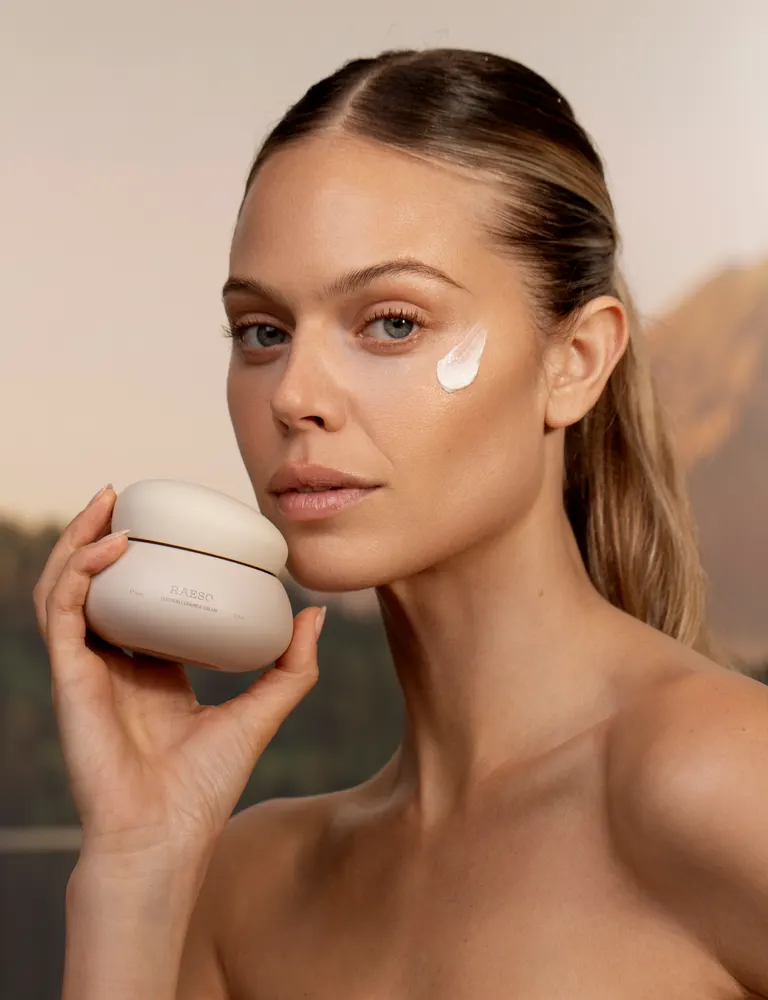 Model holding a cream jar at golden hour